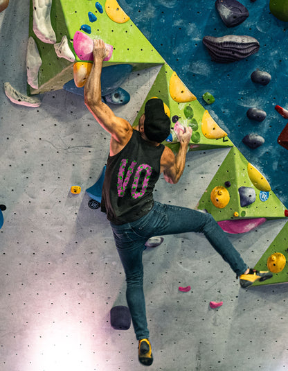 Person climbing a colorful indoor rock wall with various holds.