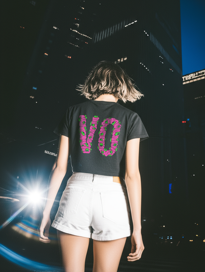 Person wearing a black t-shirt with pink text in an urban night setting
