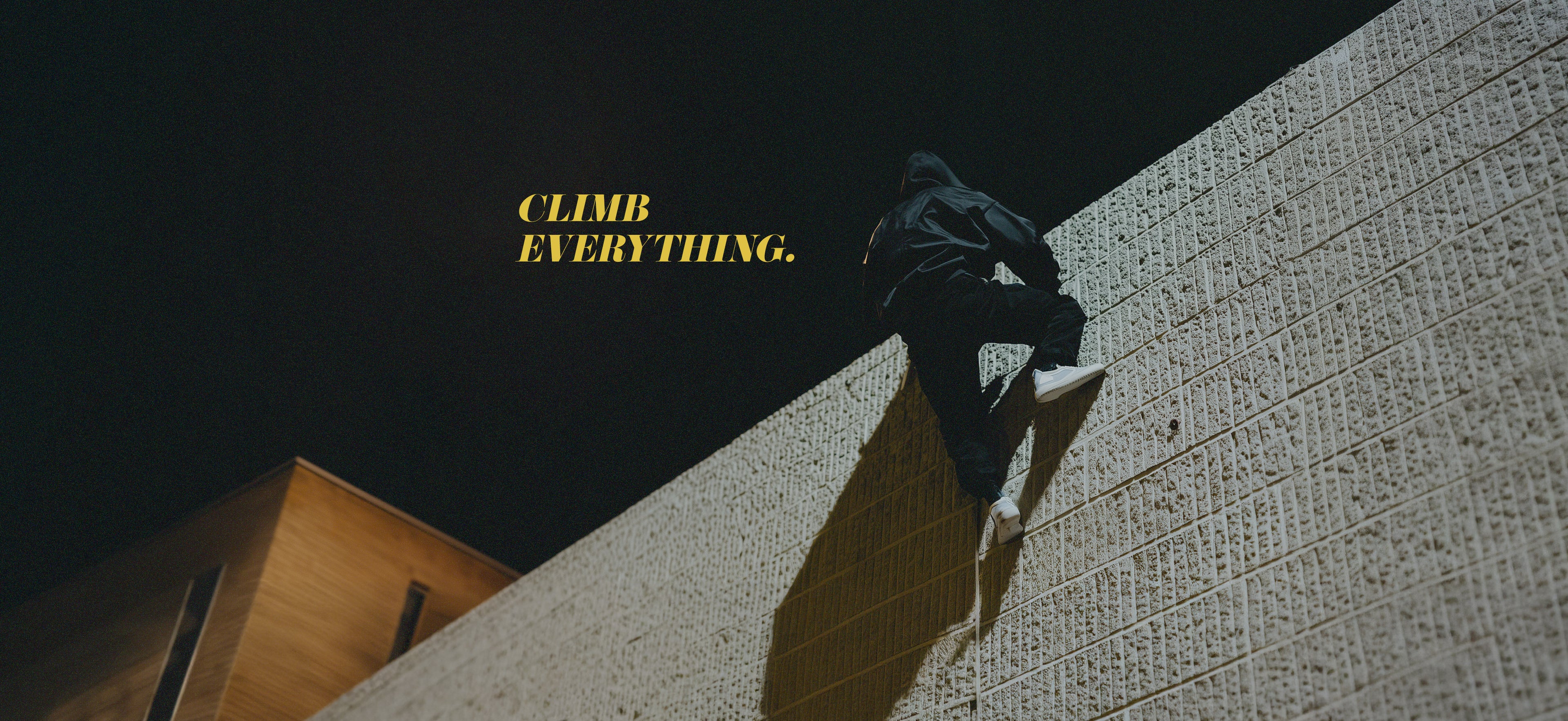 Person climbing a wall with 'CLIMB EVERYTHING.' text on a dark background