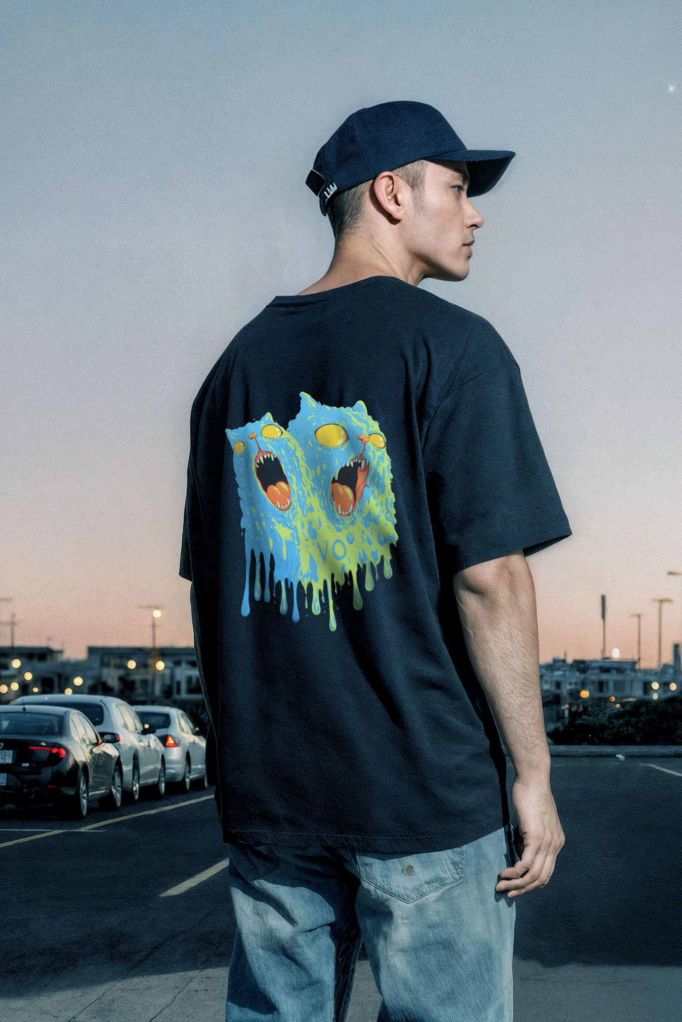 Person wearing a black t-shirt with a colorful graphic on the back, standing in an urban setting.